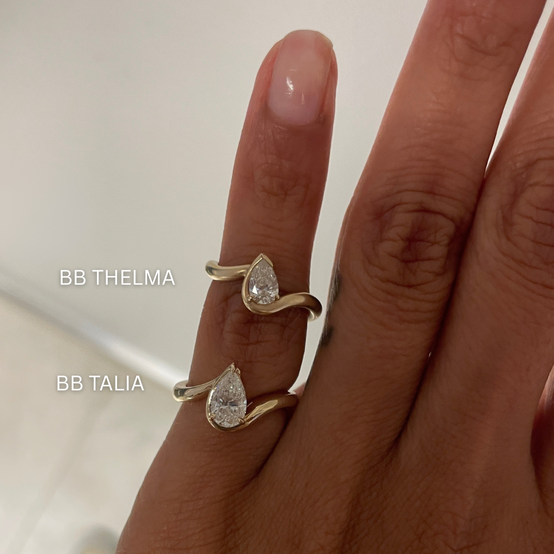 Hand model wearing BB thelma and BB Talia in 14k yellow gold on left hand pinky in front of white  background.