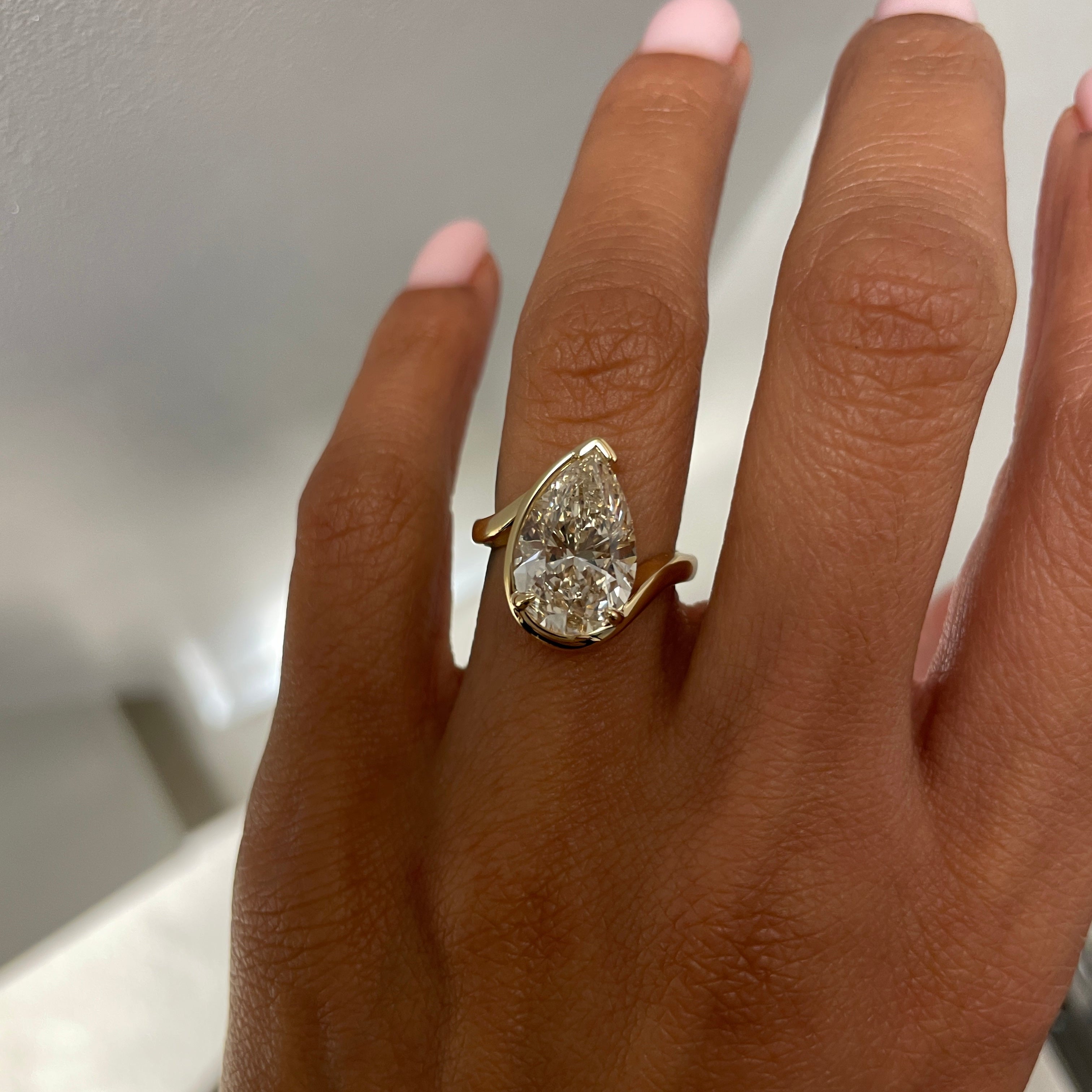 Bespoke TALIA engagement ring with faint brown pear cut diamond, satin finish 18kt yellow gold, on model