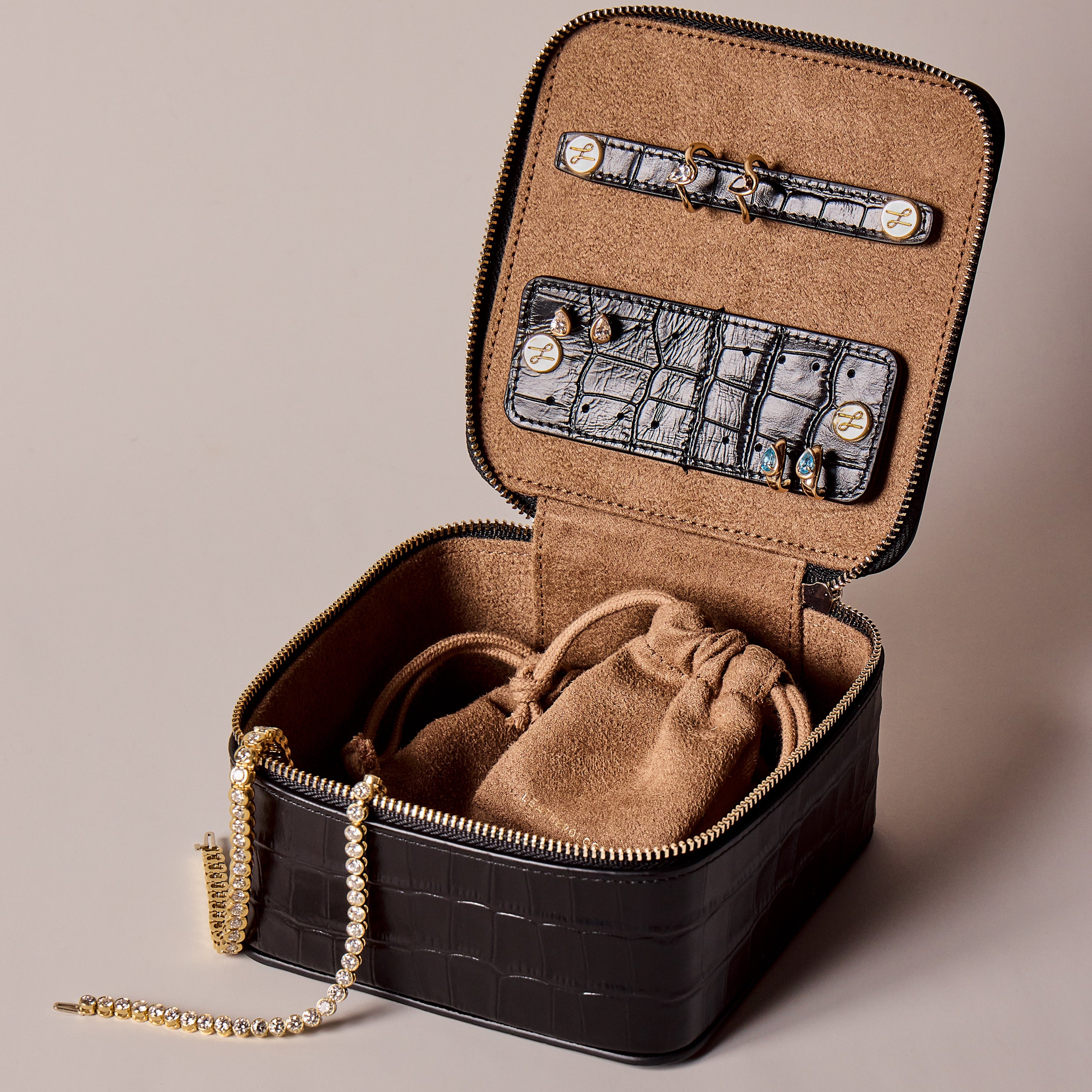 Leather Croc Travel Case with BB thelma rings and earrings in the holders. Tennis Bracelets draped over rim of bag.