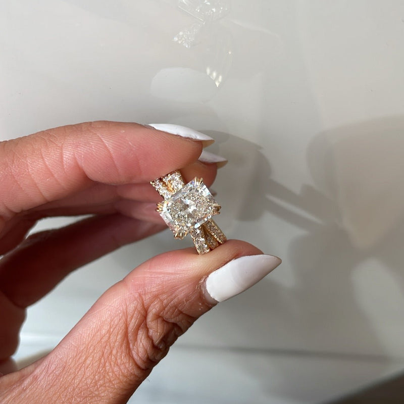 Radiant Cut Diamond On Three Overlapping Pavé Bands, held between fingers