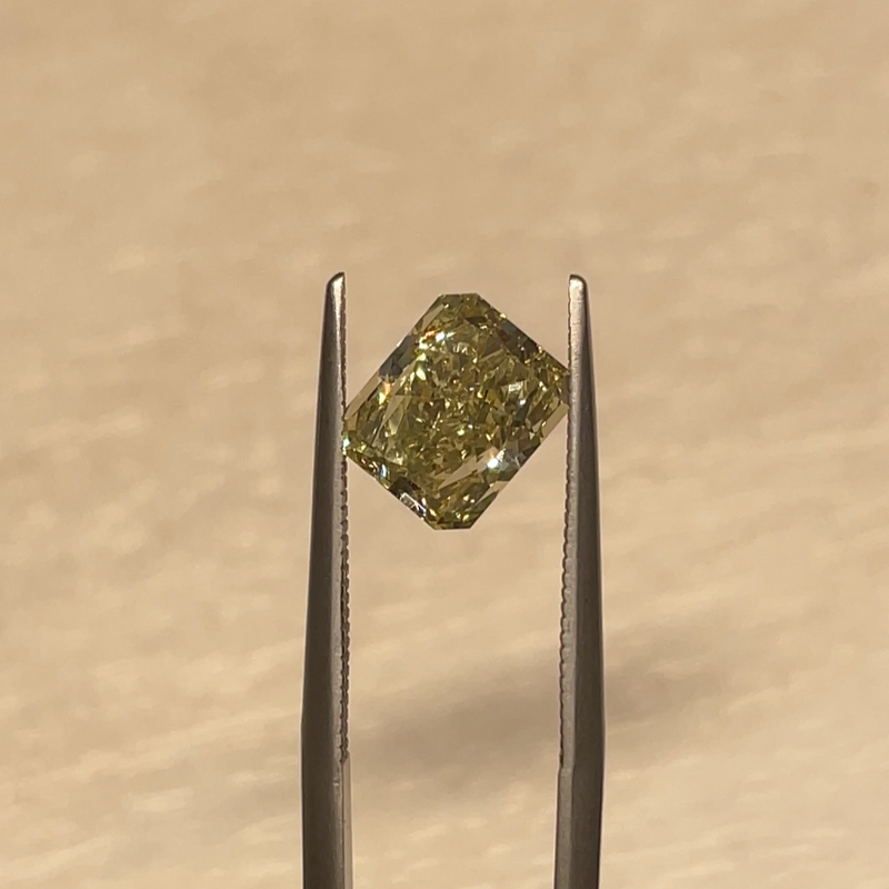 Yellowish Brown Radiant Cut Diamond, held with tweezers